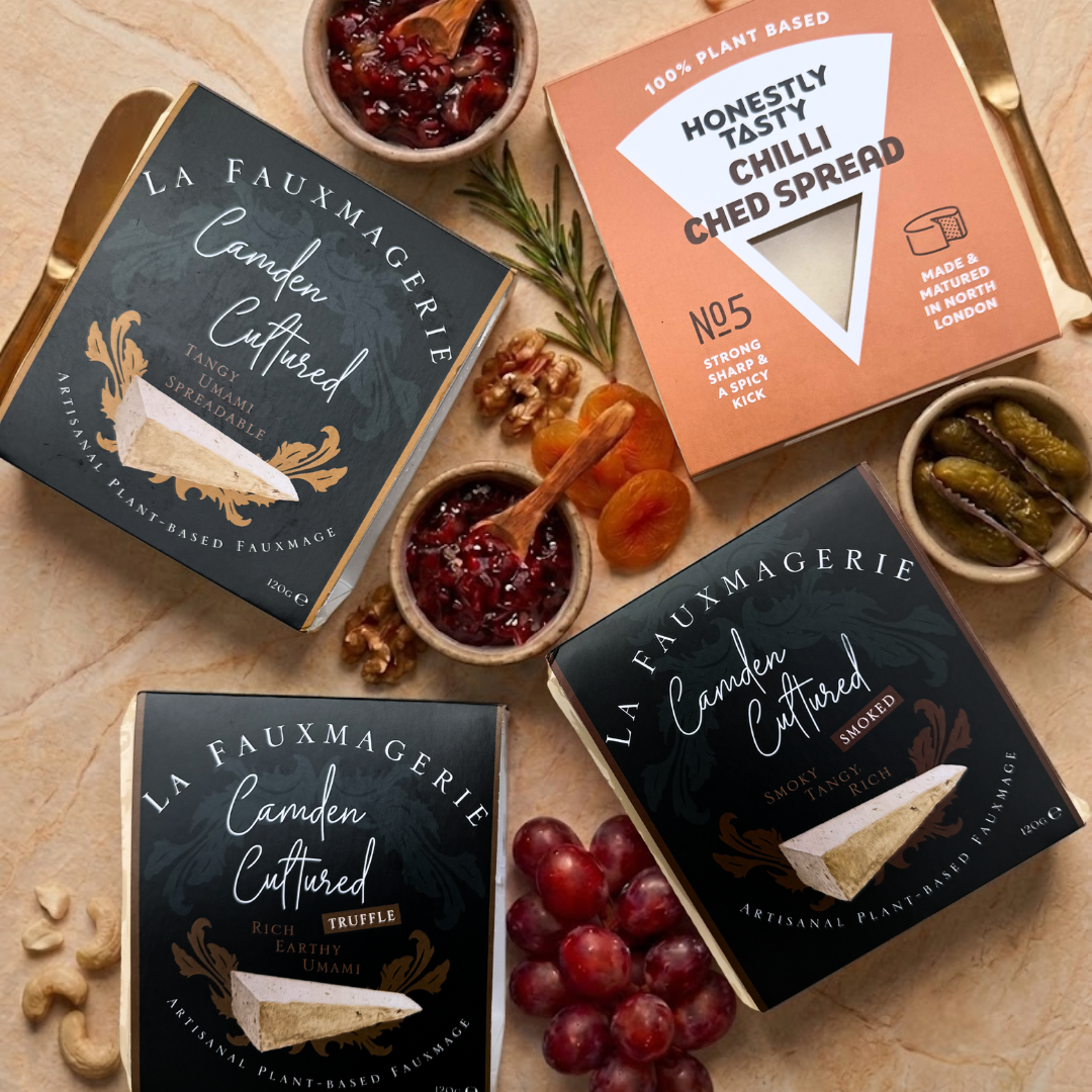 Various plant-based cheese products from La Fauxmagerie and Honestly Tasty on a wooden surface.