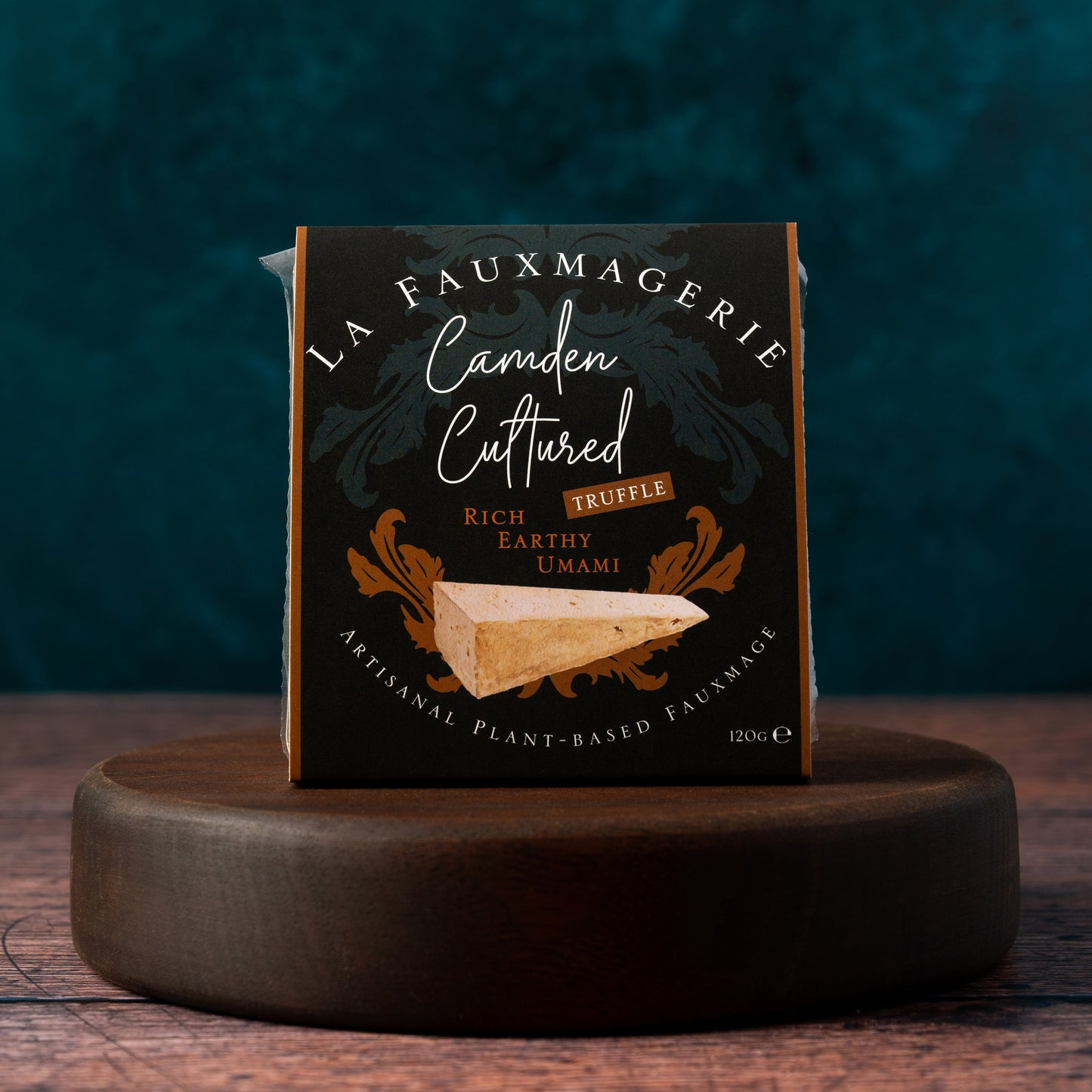Wedge of 'Camden Cultured Truffle' on a wooden stand with a dark background
