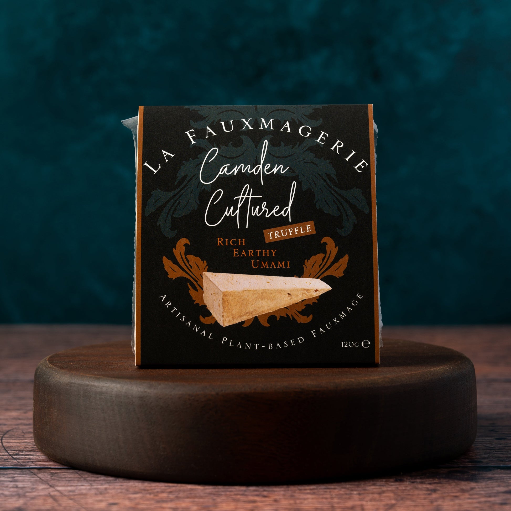 Wedge of 'Camden Cultured Truffle' on a wooden stand with a dark background